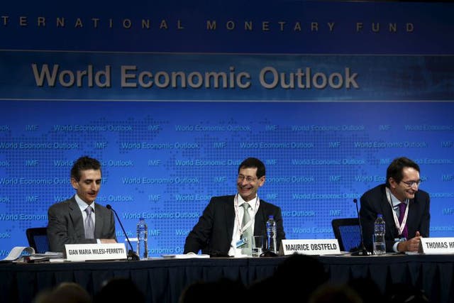 Gian Maria Milesi-Ferretti, Deputy Director, Research Department of IMF, Maurice Obstfeld Economic Counsellor and Director, Research Department of IMF and Thomas Helbling, Division Chief, Research Department of IMF (L-R) deliver the International Monetary Fund's media briefing on the world economic outlook during its annual meeting in Lima, Peru, October 6, 2015