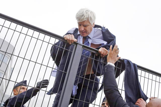 An Air France director, Pierre Plissonnier, climbs a fence to escape the mob