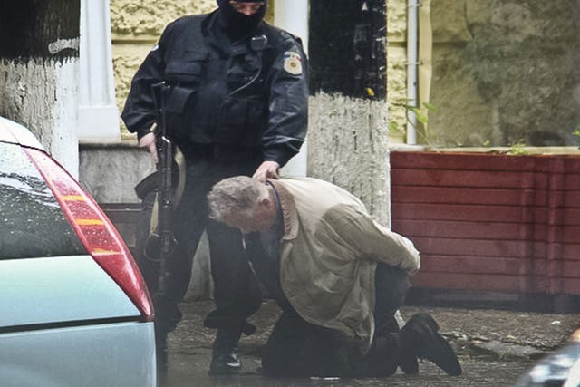 Go-between Teodor Chetrus is held by Moldovan police during a uranium-235 sting operation