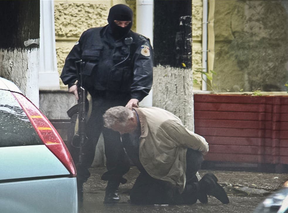 Go-between Teodor Chetrus is held by Moldovan police during a uranium-235 sting operation