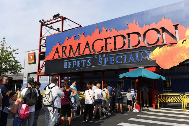 A photo taken on August 13, 2015 shows poeple queuing at the entrance to the Armageddon attraction at The Walt Disney Studios park of Disneyland Paris in Marne-la-Vallee