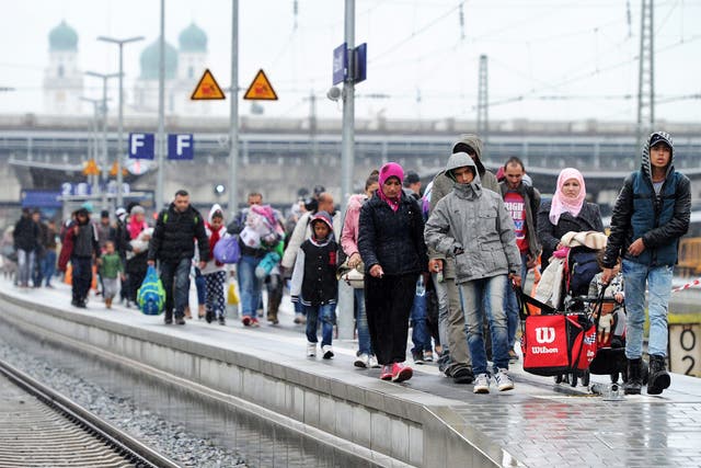 Refugees walk along the platform at the train station in Passau, Germany