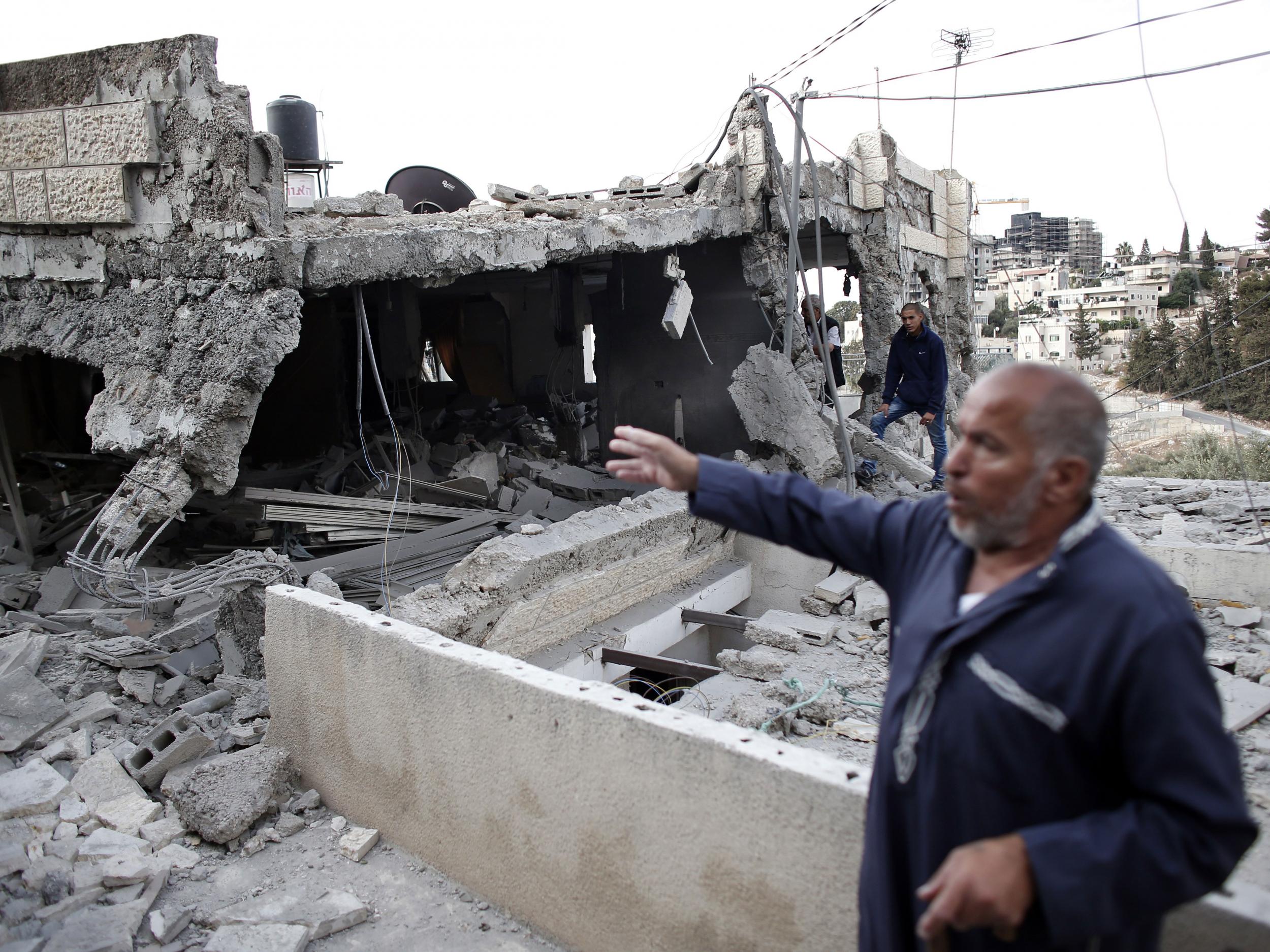 A Palestinian man shows the rubble of a destroyed house after Israeli security forces demolished the homes of two Palestinians behind attacks in the Palestinian neighborhood of Jabal Mukaber in east Jerusalem, on October 6, 2015