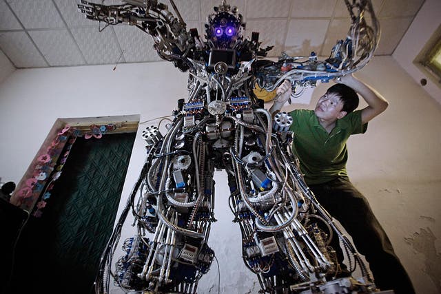 Chinese inventor Tao Xiangli modifies the circuits of his home-made robot at his house in Beijing, May 15, 2013