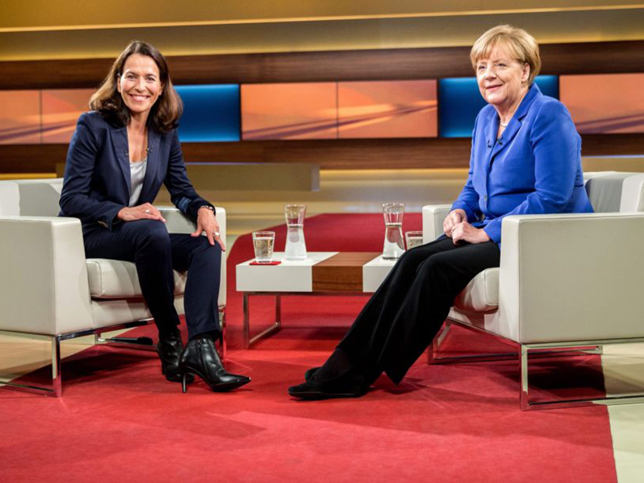 Angela Merkel (R) poses with TV host Anne Will prior to the interview in Berlin