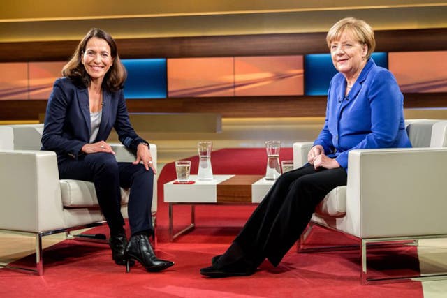 Angela Merkel (R) poses with TV host Anne Will prior to the interview in Berlin