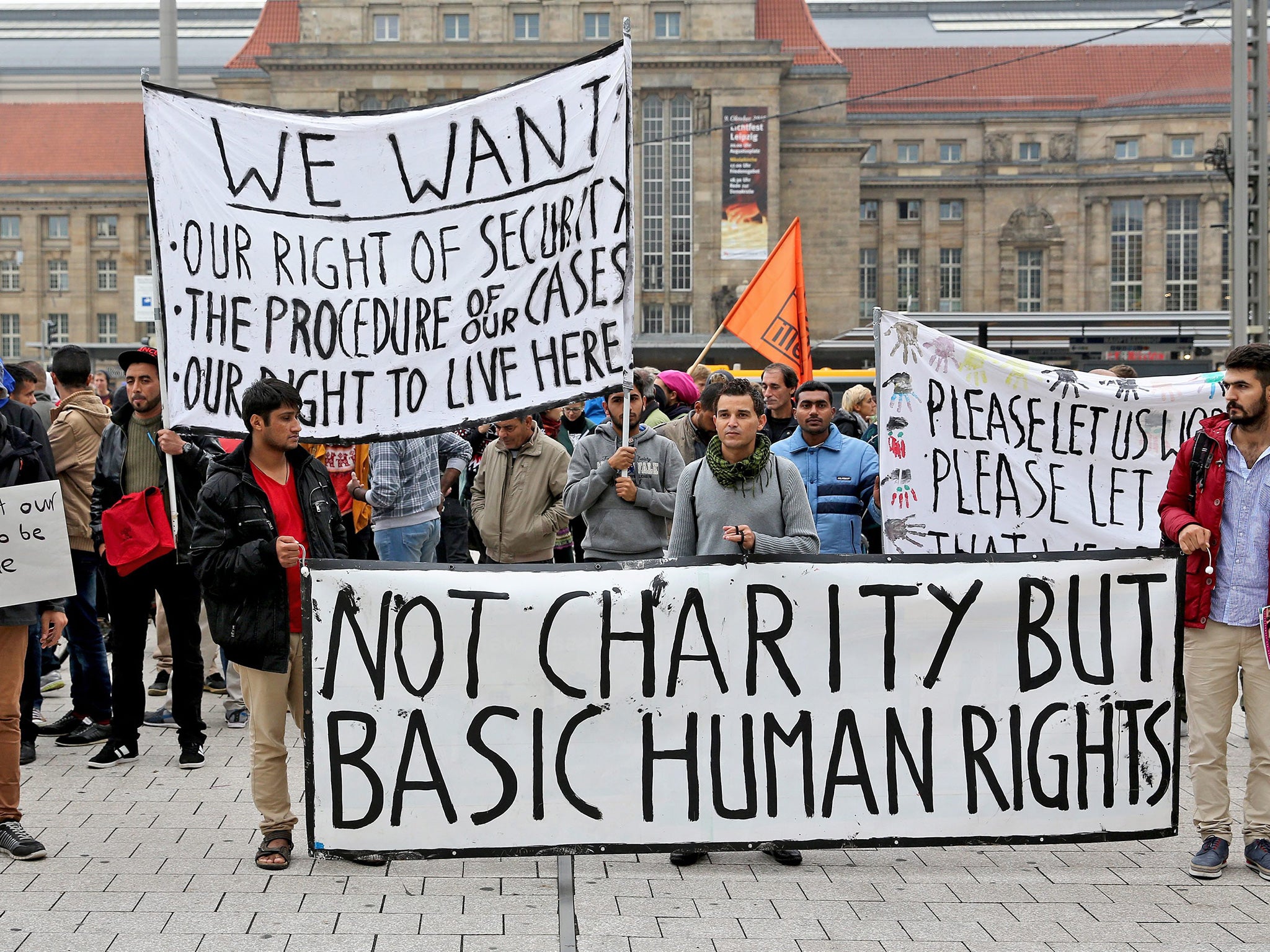 Refugees hold up banners during a rally held in support of better treatment and speedier processing of their cases, in Leipzig, Germany