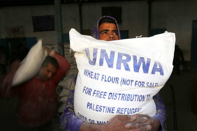 Palestinians receiving their monthly food aid at a UN distribution centre in the Rafah refugee camp, southern Gaza, earlier this year