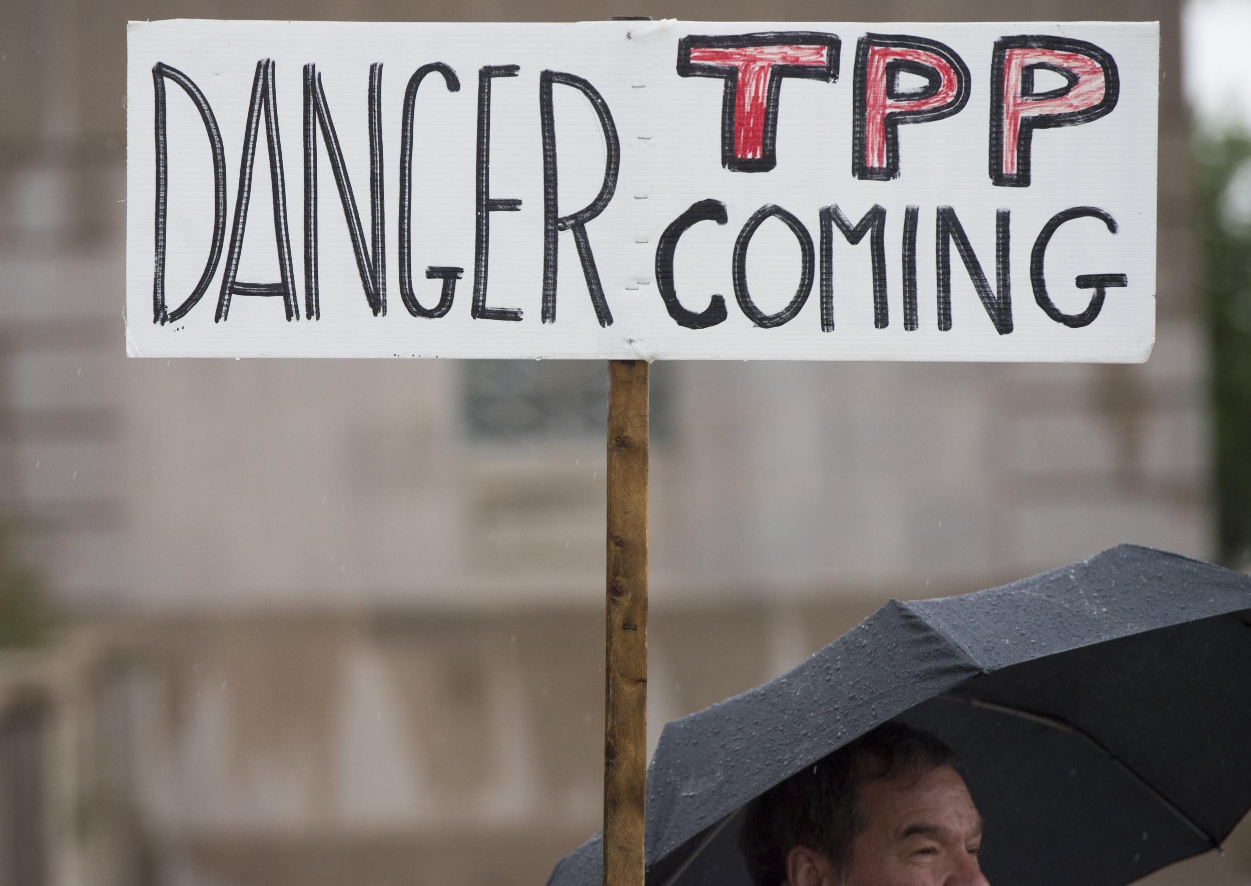 A protestor holds an anti-TPP banner