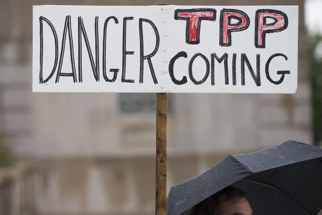 A protestor holds an anti-TPP banner