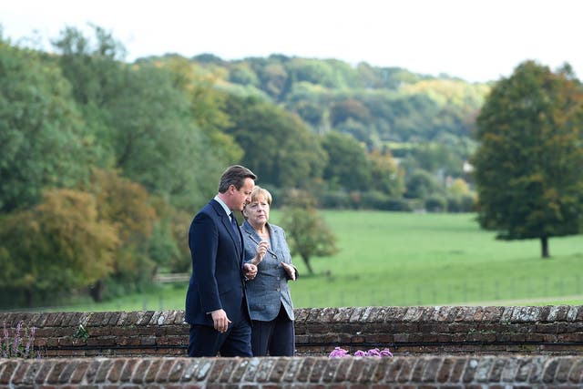 British Prime Minister David Cameron (L) and German Chancellor Angela Merkel (R) chat in the Rose Garden at Chequers in Ellesborough