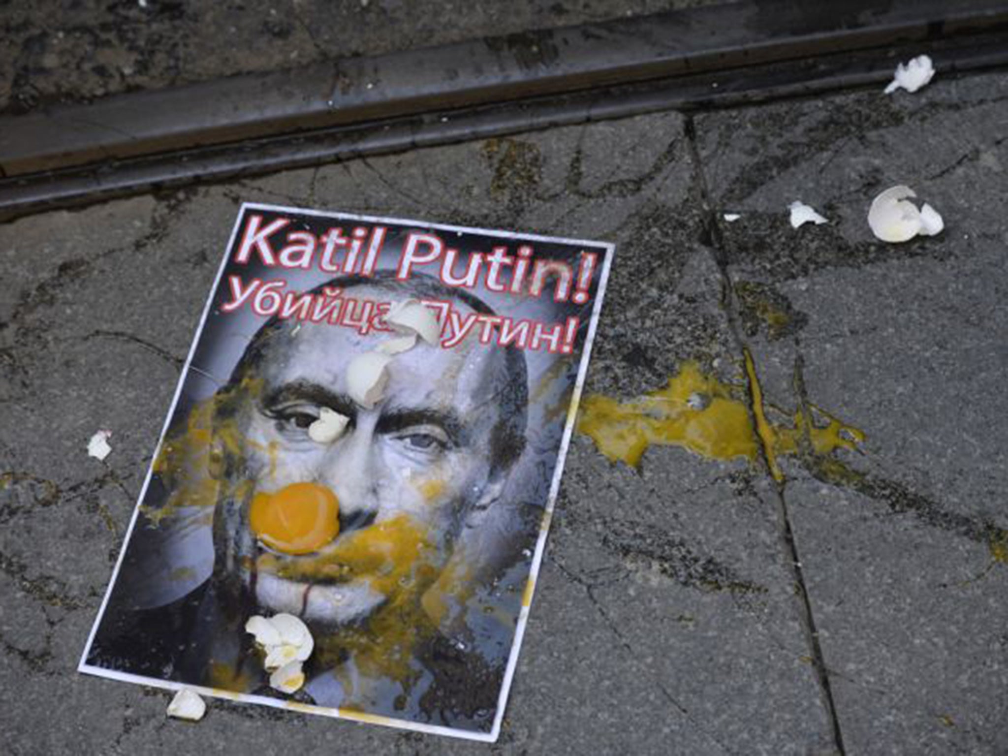 A picture depicting Russian President Vladimir Putin is splattered with eggs during a protest against Russian military operations in Syria, in Istanbul,