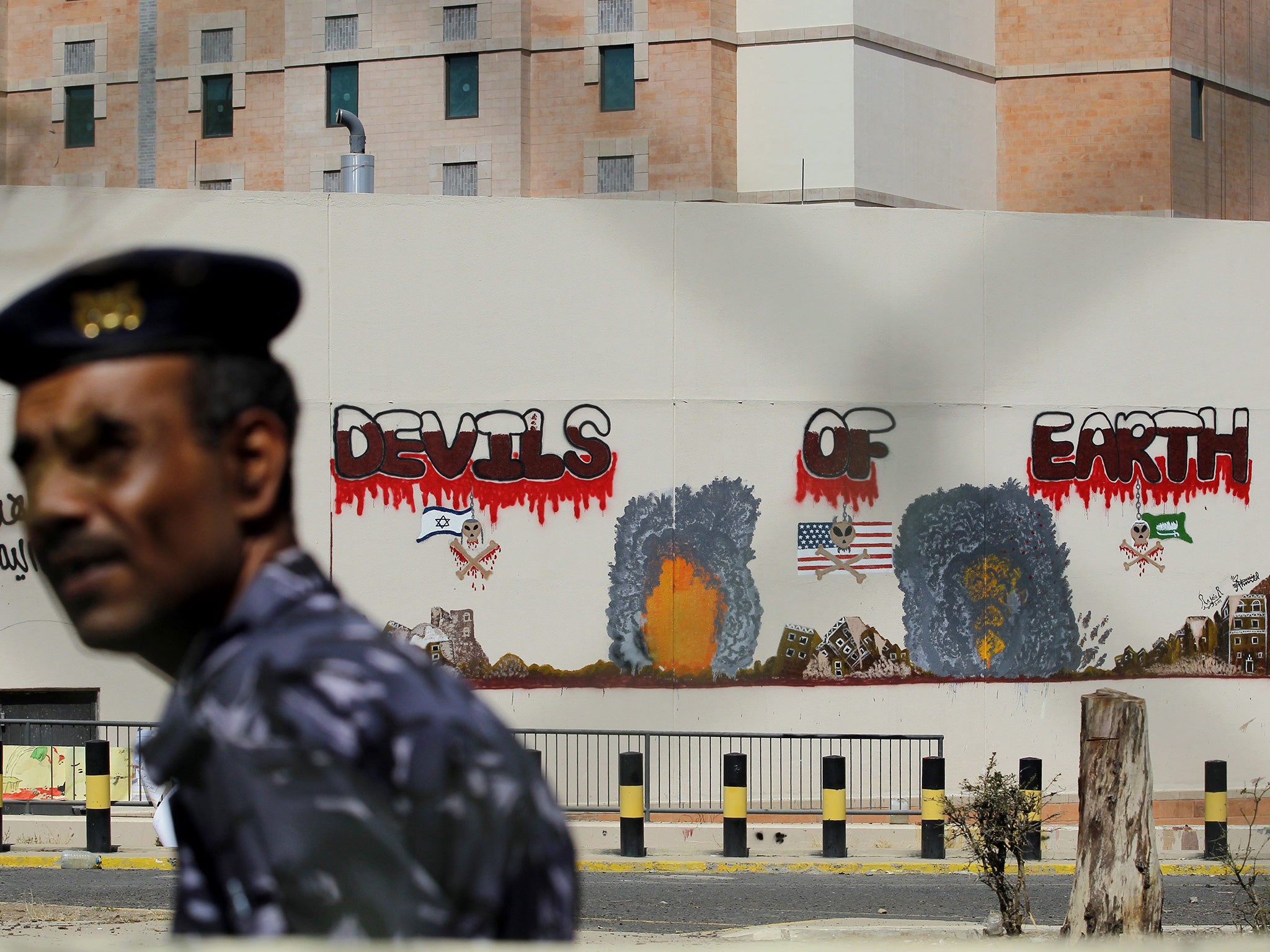 A Yemeni walks by in front of the grafitti sprayed wall of the closed US embassy in Sana'a