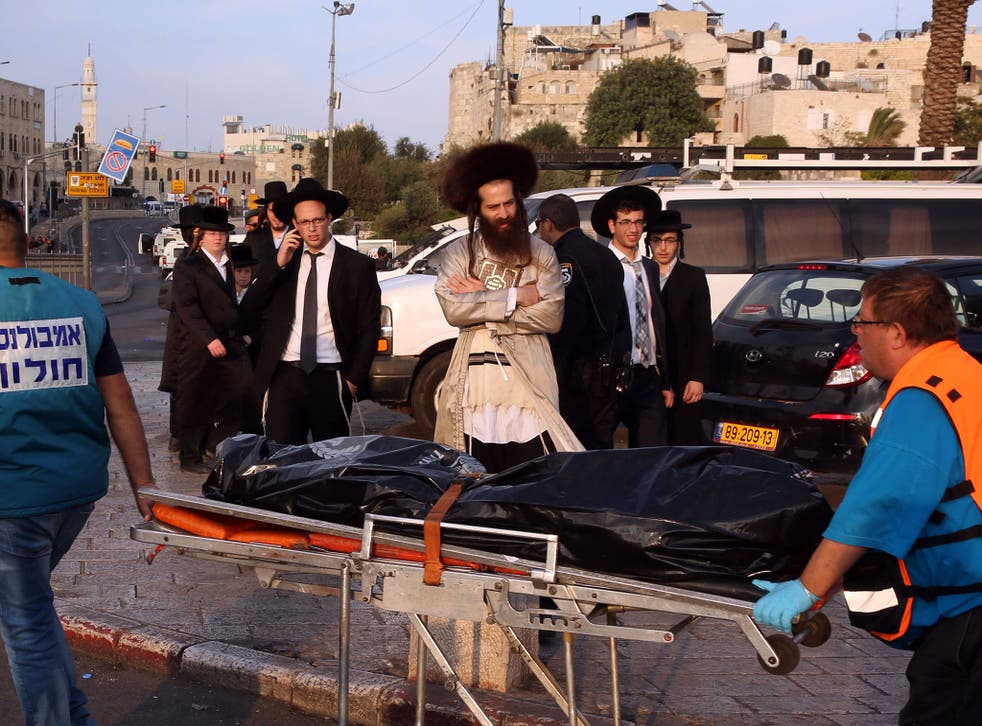 Israeli medics evacuate the body of a Palestinian teenager who was shot dead by Israeli security forces after he stabbed two police officers, on October 10
