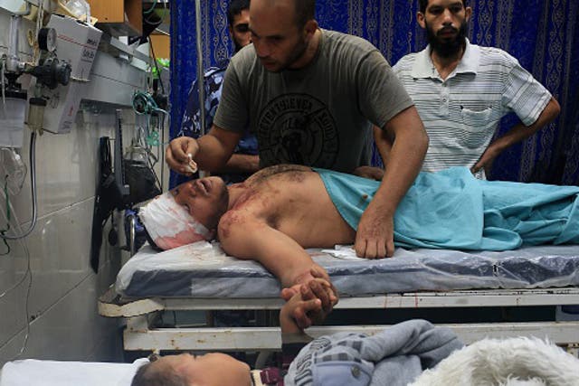 File: Medical teams treat a man and small boy in Gaza after a house is bombed