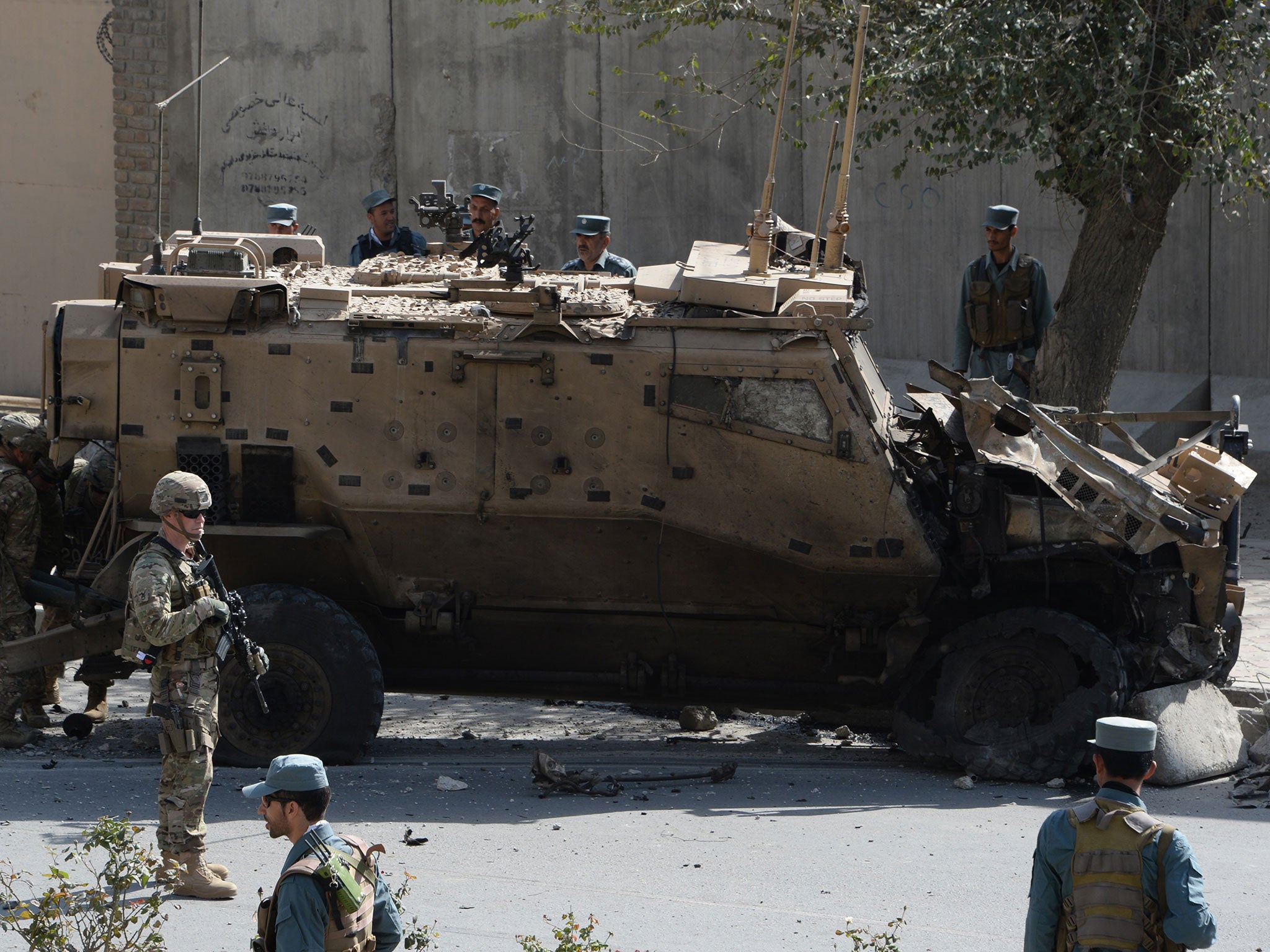 NATO soldiers and Afghan security forces investigate site of a bomb attack that targeted foreign military vehicles at Jo-e-Sher in Kabul on October 11, 2015.