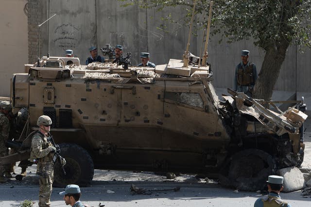 NATO soldiers and Afghan security forces investigate site of a bomb attack that targeted foreign military vehicles at Jo-e-Sher in Kabul on October 11, 2015.