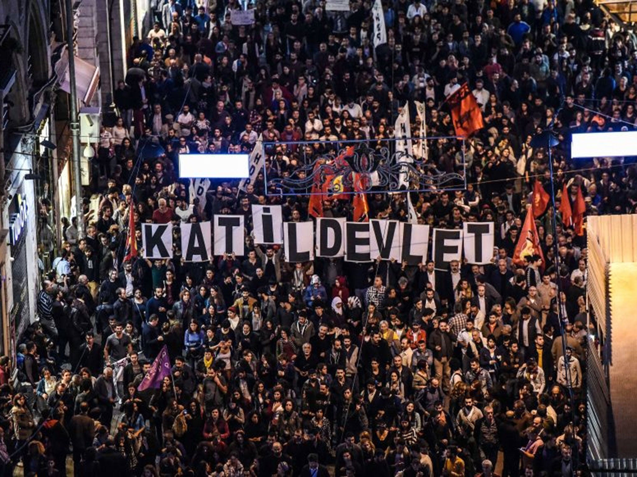 Placards reading "Killer state" are seen as thousands of protesters take part in a march against the deadly attack earlier in Ankara on October 10, 2015 at the Istiklal avenue in Istanbul.