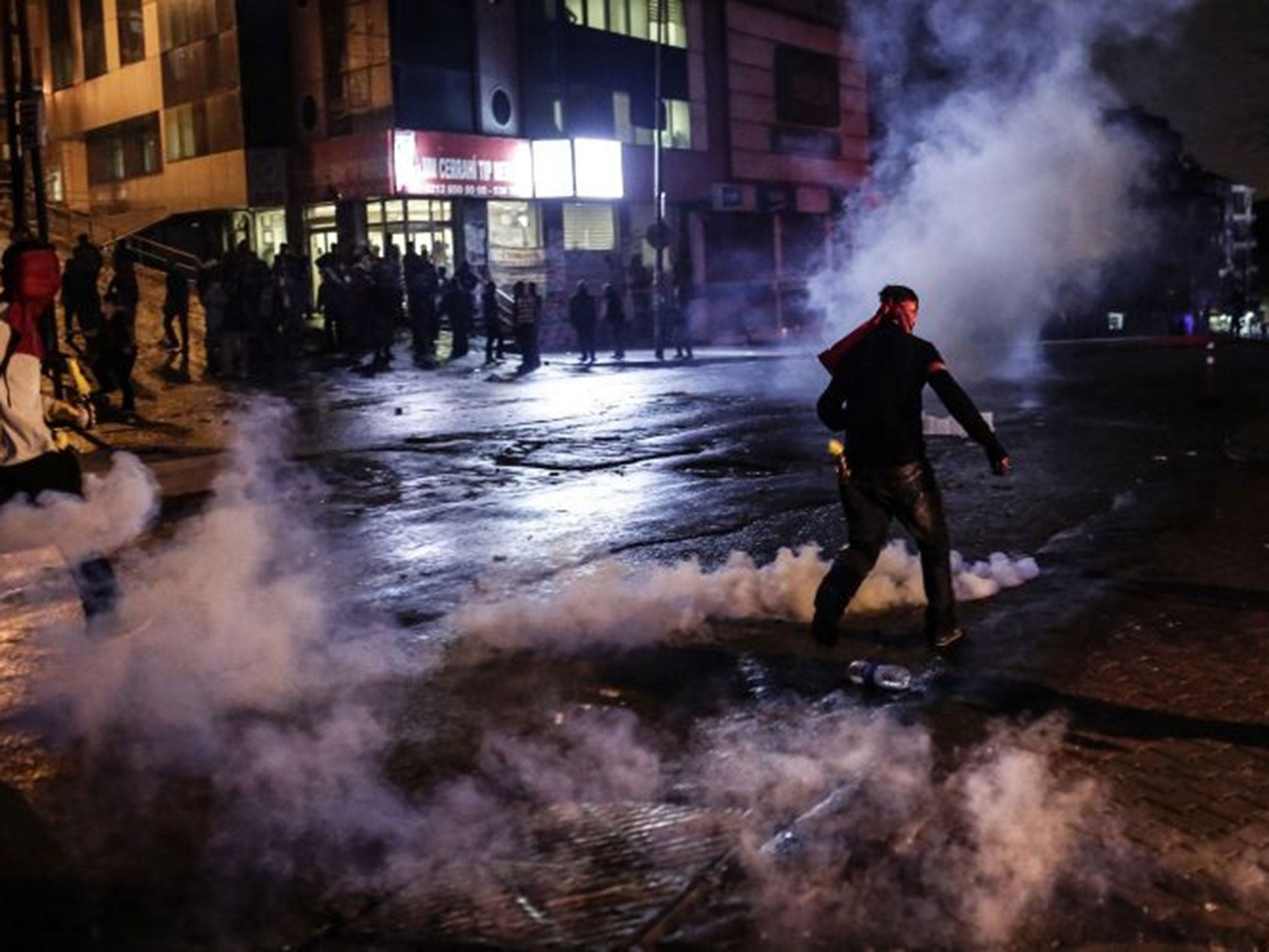 Protesters run away from tear gas during clashes with police on October 10, 2015 at the Gazi district in Istanbul, hours after the deadly attack in Ankara.