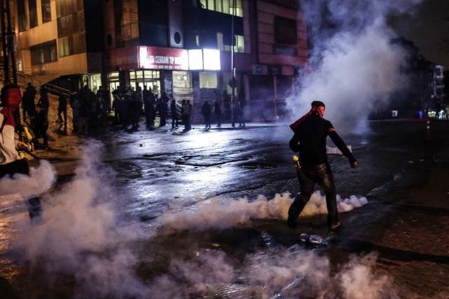 Protesters run away from tear gas during clashes with police on October 10, 2015 at the Gazi district in Istanbul, hours after the deadly attack in Ankara.