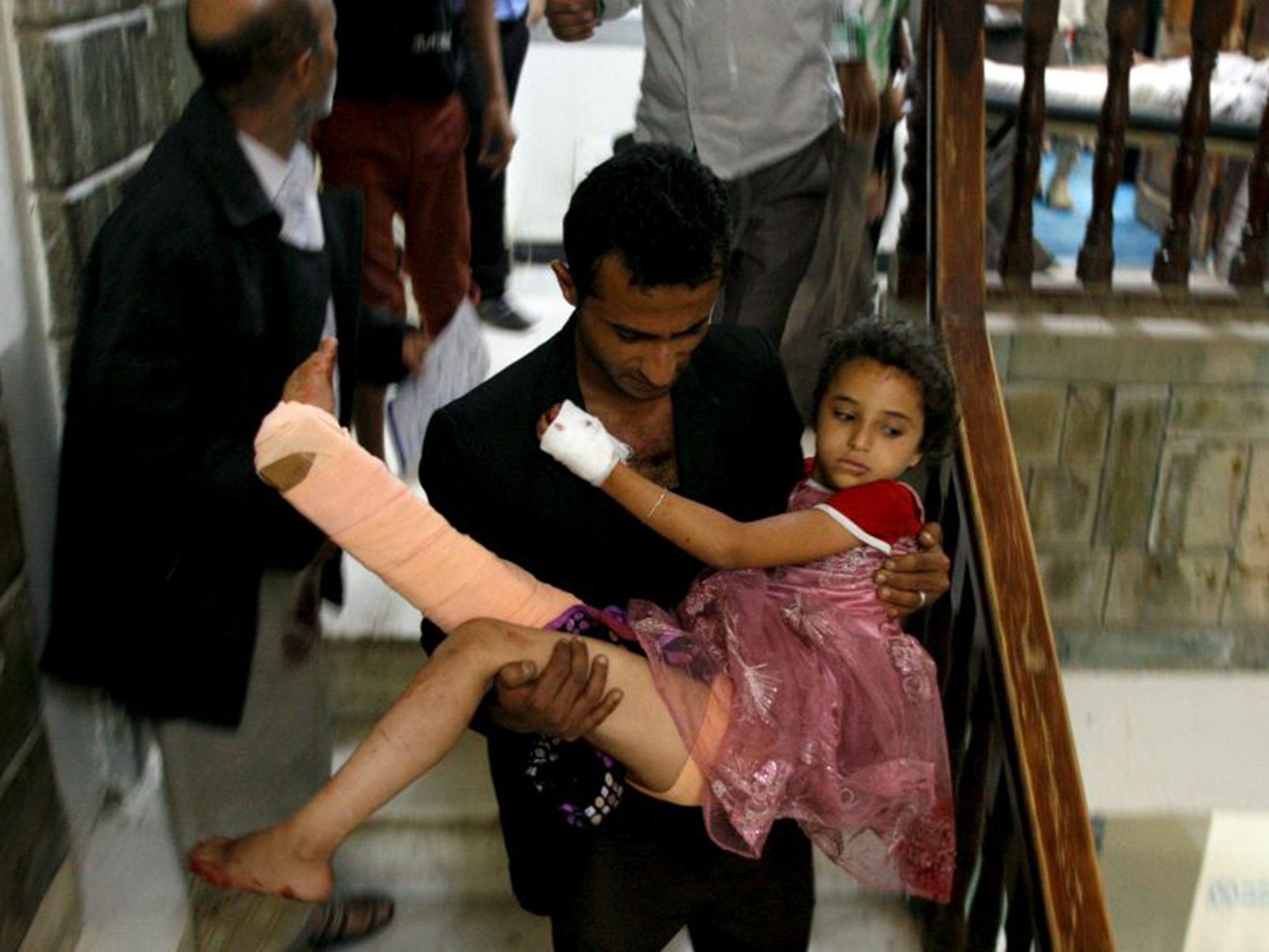 A man carries his sister after she received treatment at a hospital in Taiz. Hundreds of thousands of people are trapped in the city by a blockade of Shia Houthi rebels