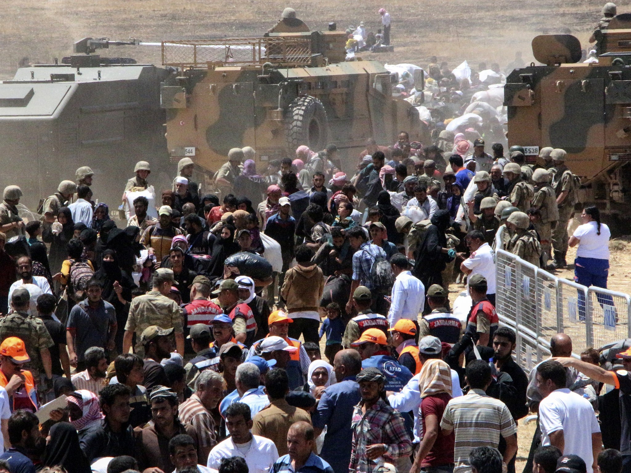 Thousands of refugees cross from Syria into Turkey, fleeing clashes pitting Kurdish fighters against the Isis group