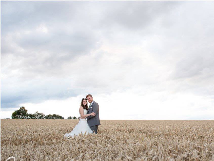 This couple posed in a field. Chris Chambers Photography.