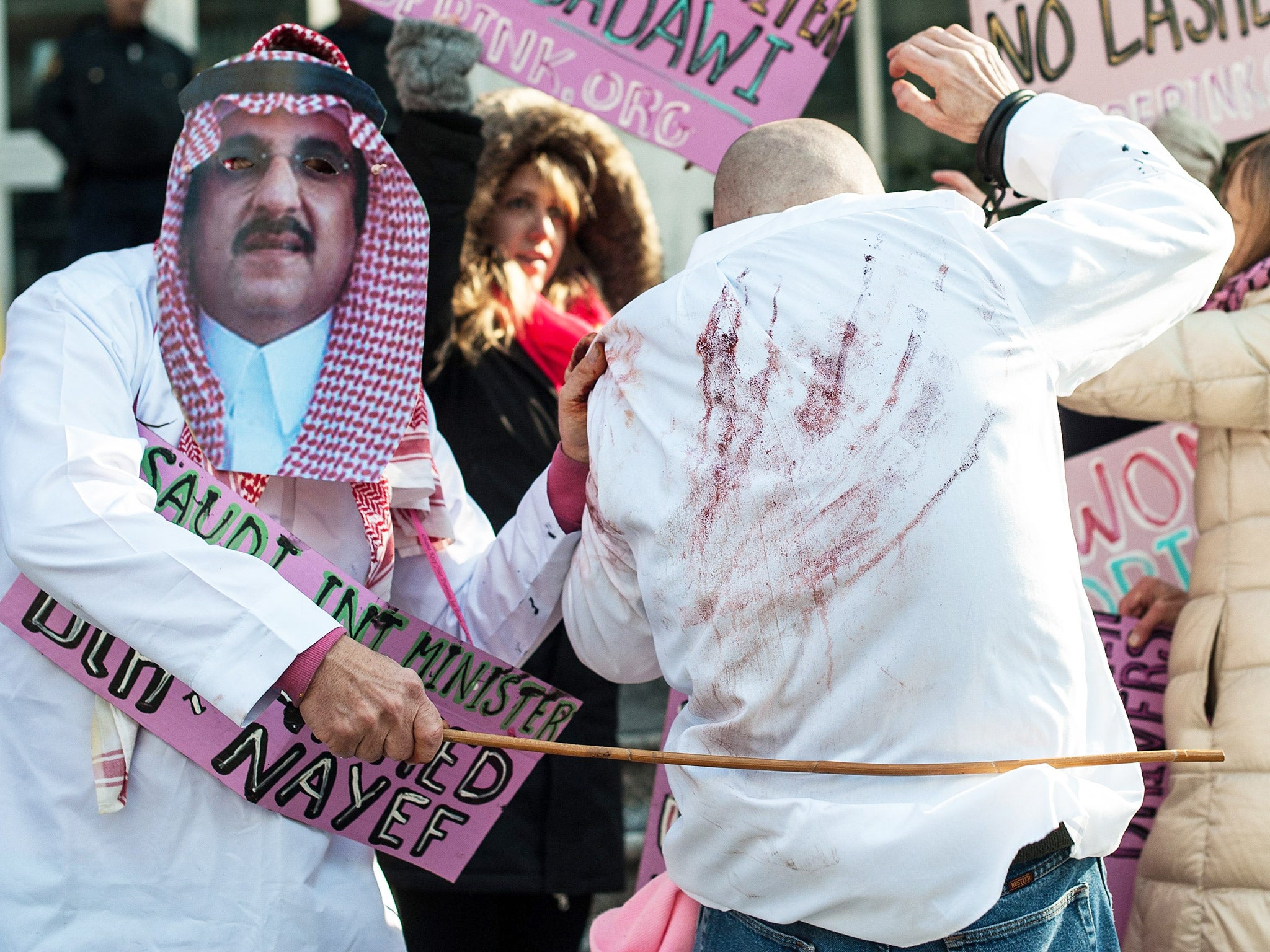 Protesters simulate a flogging in front of the Saudi embassy in Washington, DC during a demonstration against the punishment of activist Raef Badawi, earlier this year