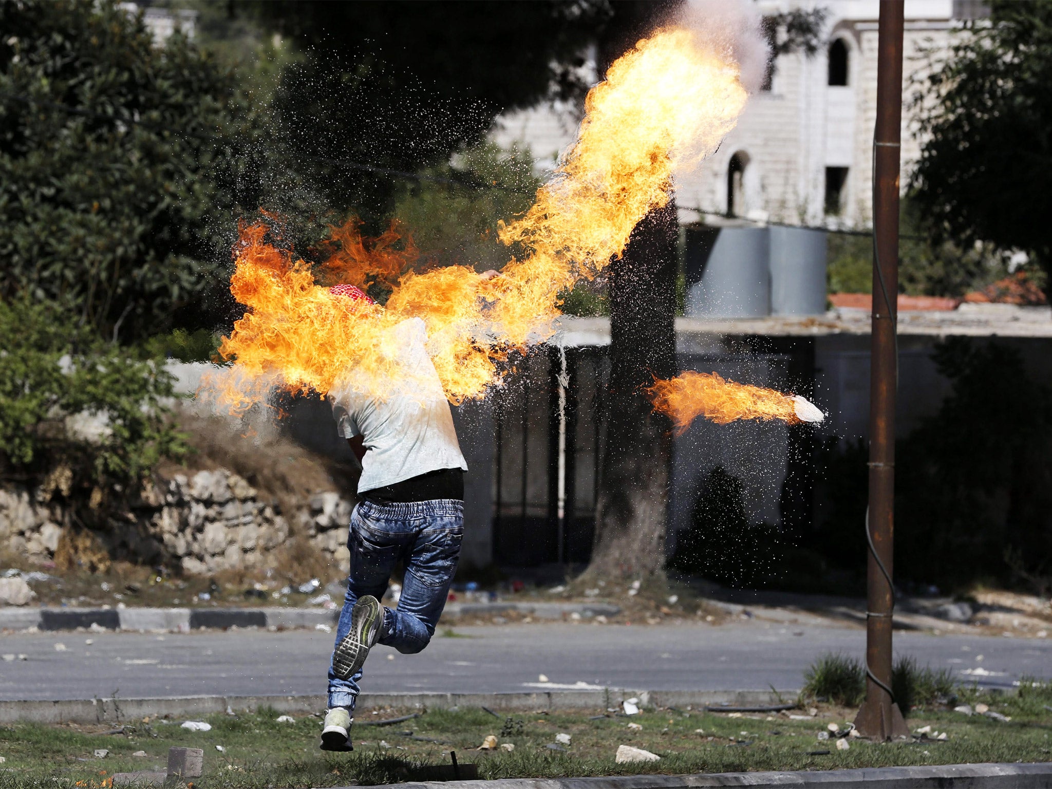 A Palestinian protester throws a molotov cocktail during clashes with Israeli armed forces in Hebron