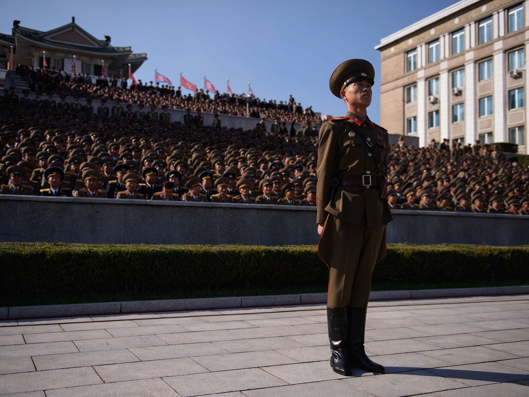A member of a North Korean honour guard stands before spectators prior to a mass military parade at Kim Il-Sung square