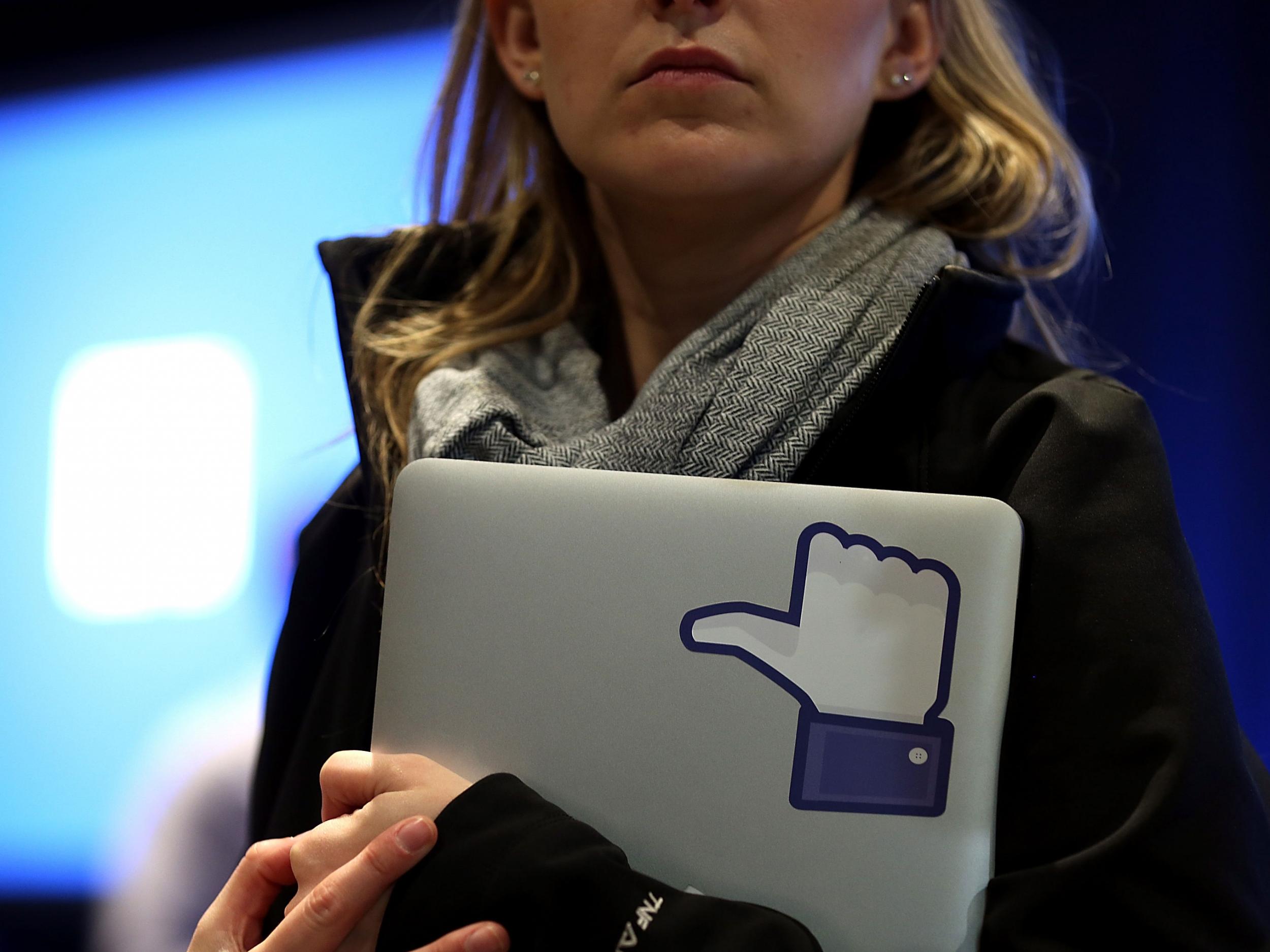 A Facebook employee holds a laptop with a 'like' sticker on it during an event at Facebook headquarters during an event at Facebook headquarters on April 4, 2013 in Menlo Park, California