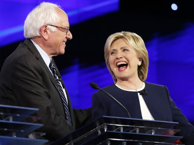 Bernie Sanders and Hillary Clinton laugh during Tuesday night's debate