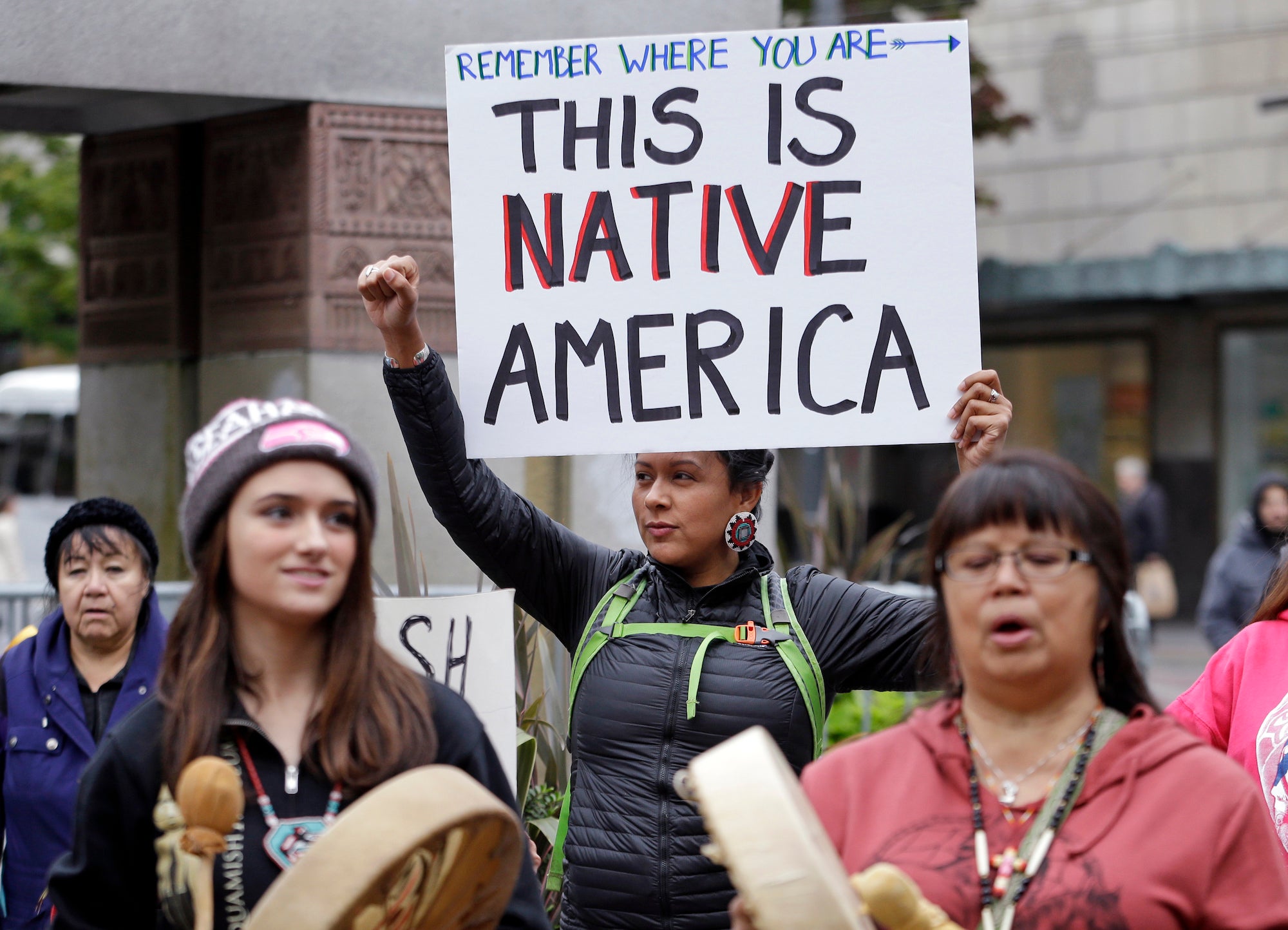 Ruth Sims, a Navajo/Oglala Sioux, holds a sign during a demonstration for Indigenous Peoples Day in Seattle.