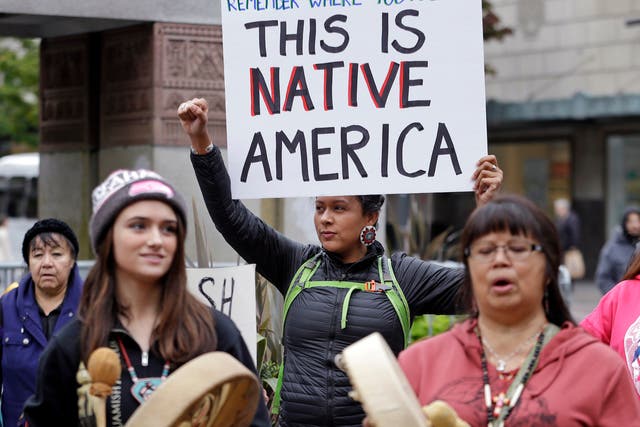Ruth Sims, a Navajo/Oglala Sioux, holds a sign during a demonstration for Indigenous Peoples Day in Seattle.