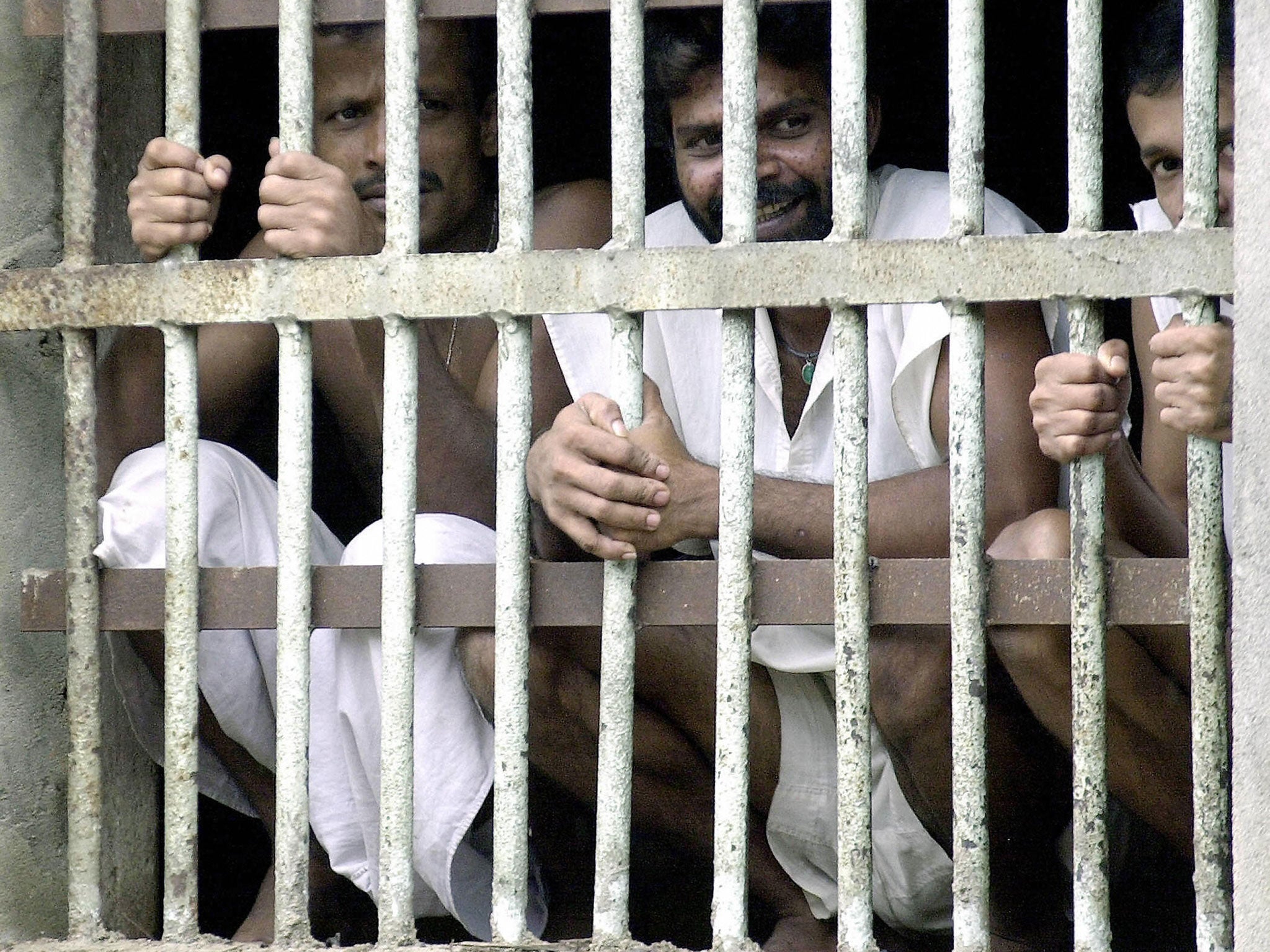 Inmates at Sri Lanka's main jail look through the bars of their cells in Colombo, 4 May 2004