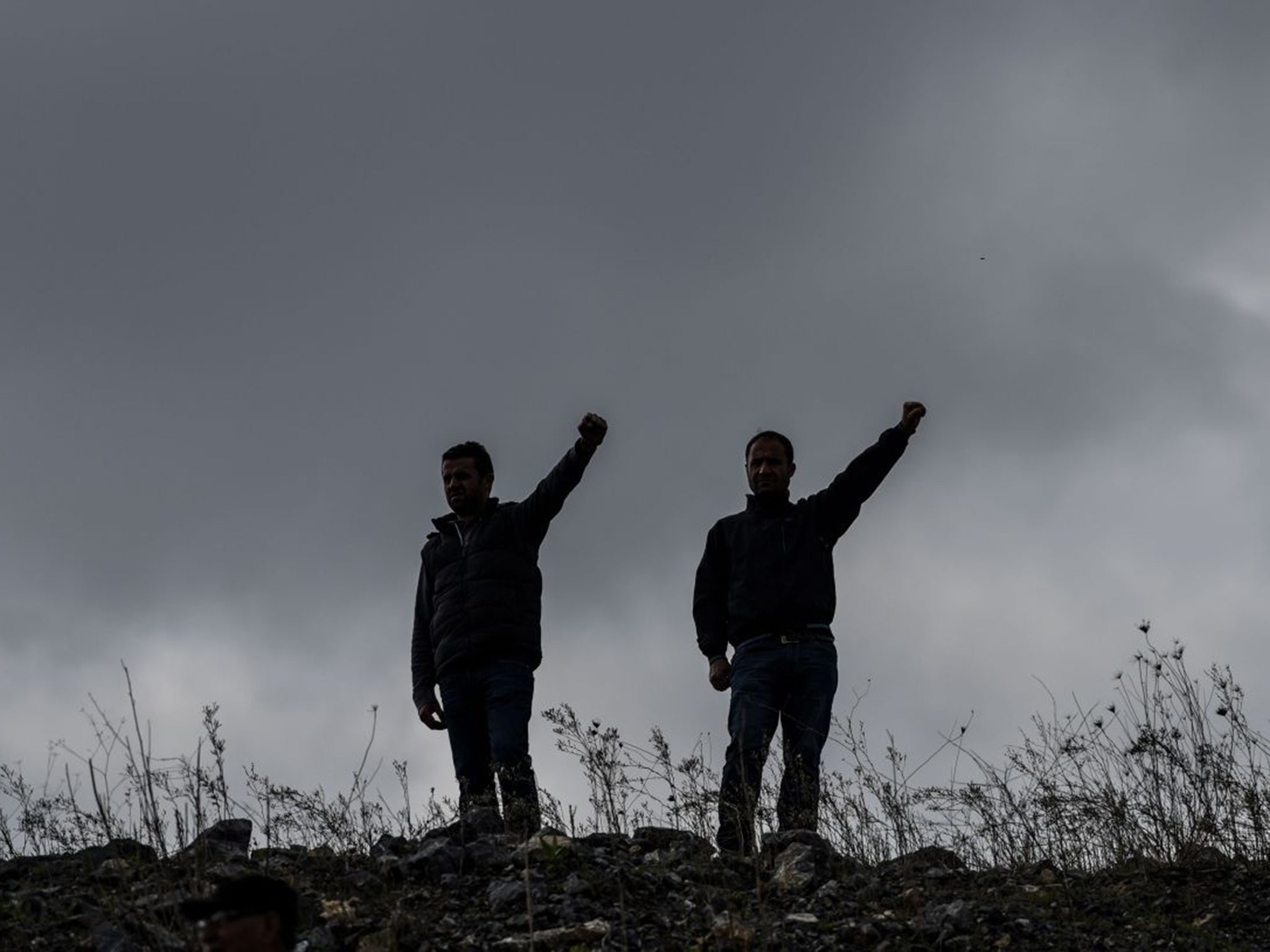 Two men raise their hands in memory of victims of the twin bombings in Ankara. The suicide attack is further polarising relations between Turks and Kurds