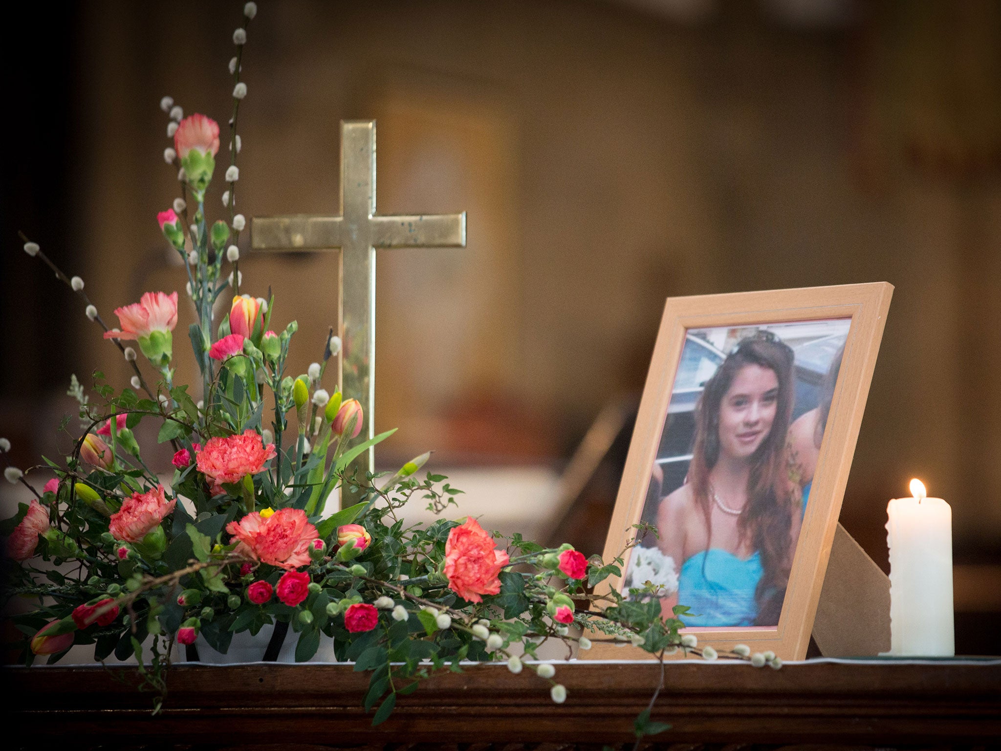 A candle burns besides a photograph of Becky Watts