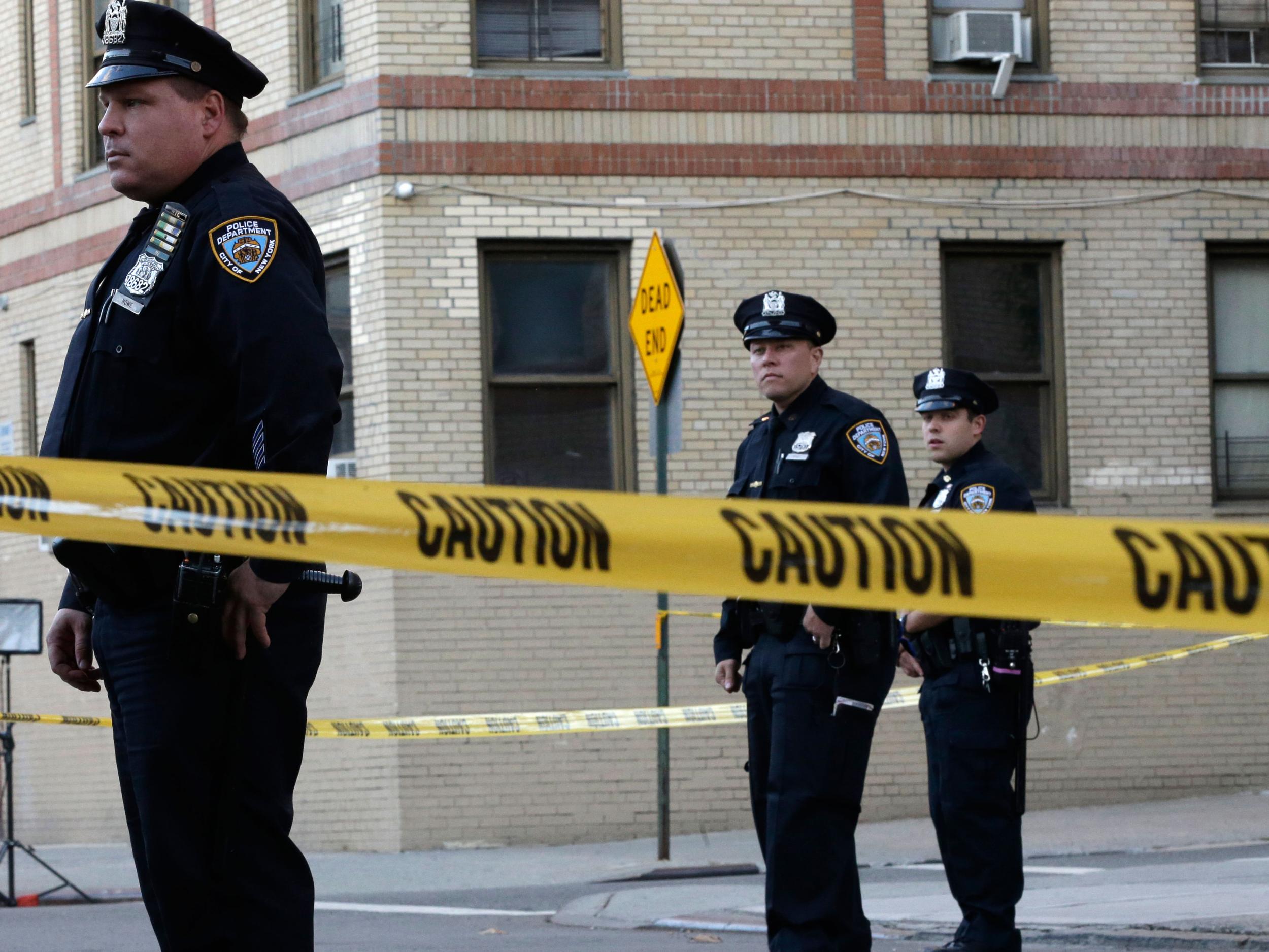 Police officers stand guard near an apartment building in the Bronx borough after the baby was thrown out of the window