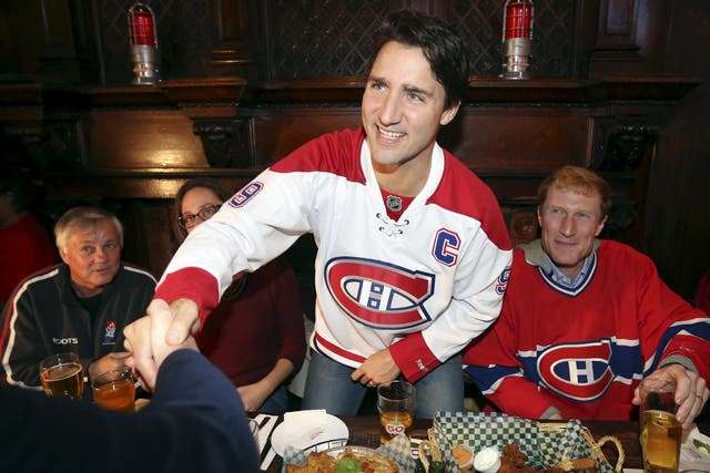 Liberal leader Justin Trudeau shakes hands while watching a Montreal Canadiens hockey game at a bar in Montreal, Quebec,