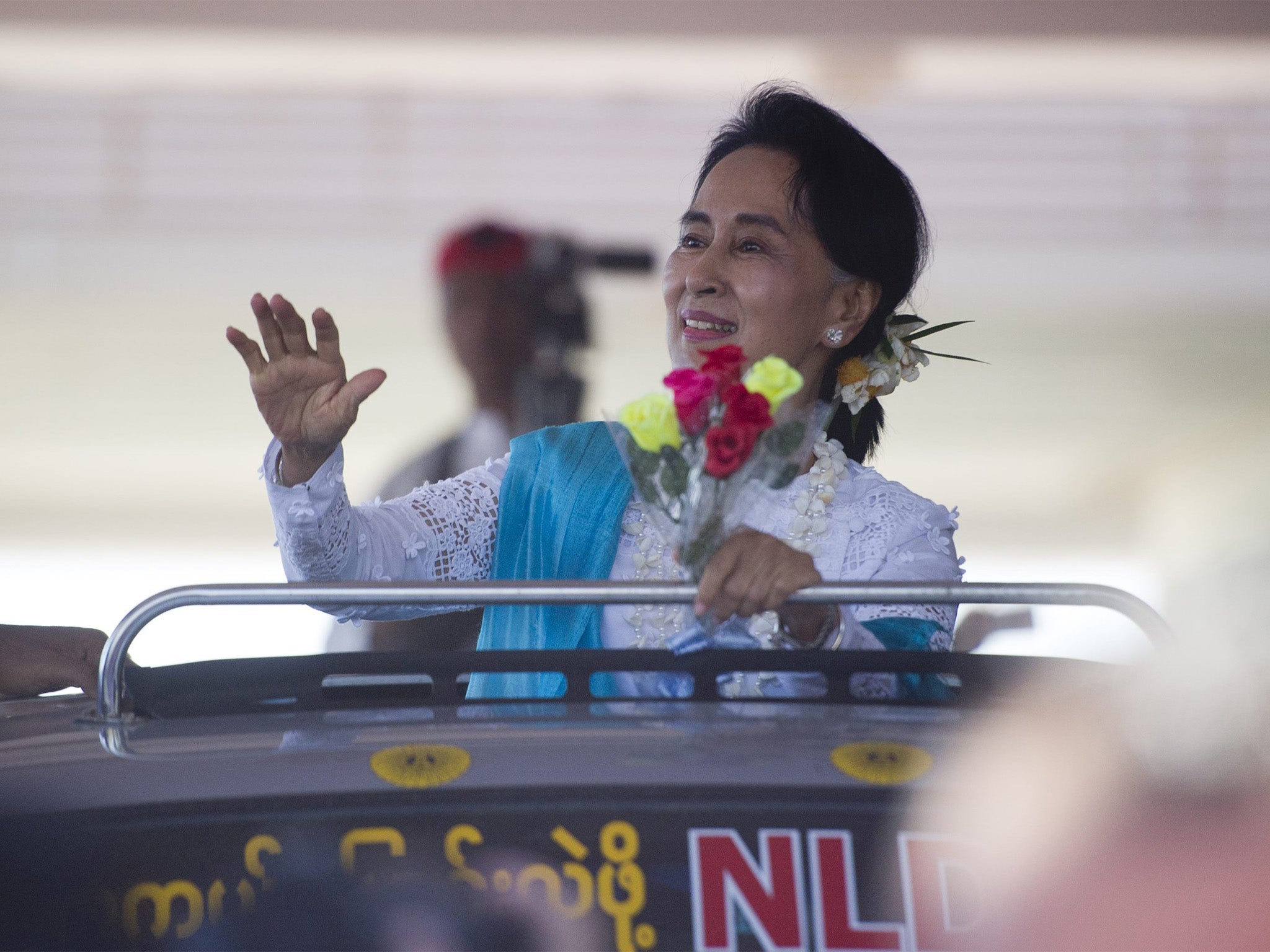 Aung San Suu Kyi waves to supporters during a campaign rally at Thandwe city in Rakhine State