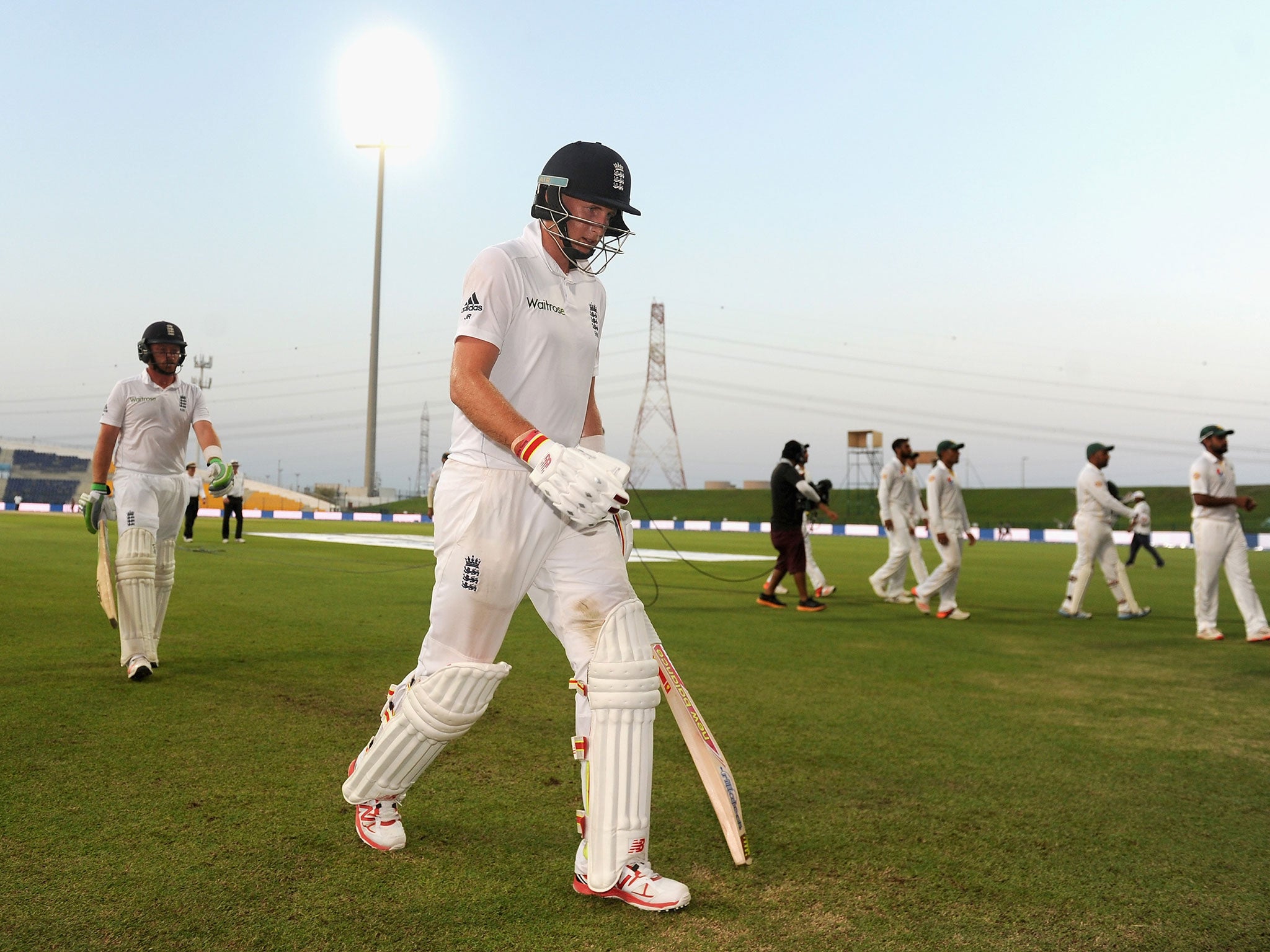 Joe Root and Ian Bell of England leave the field after bad light stops play on day five