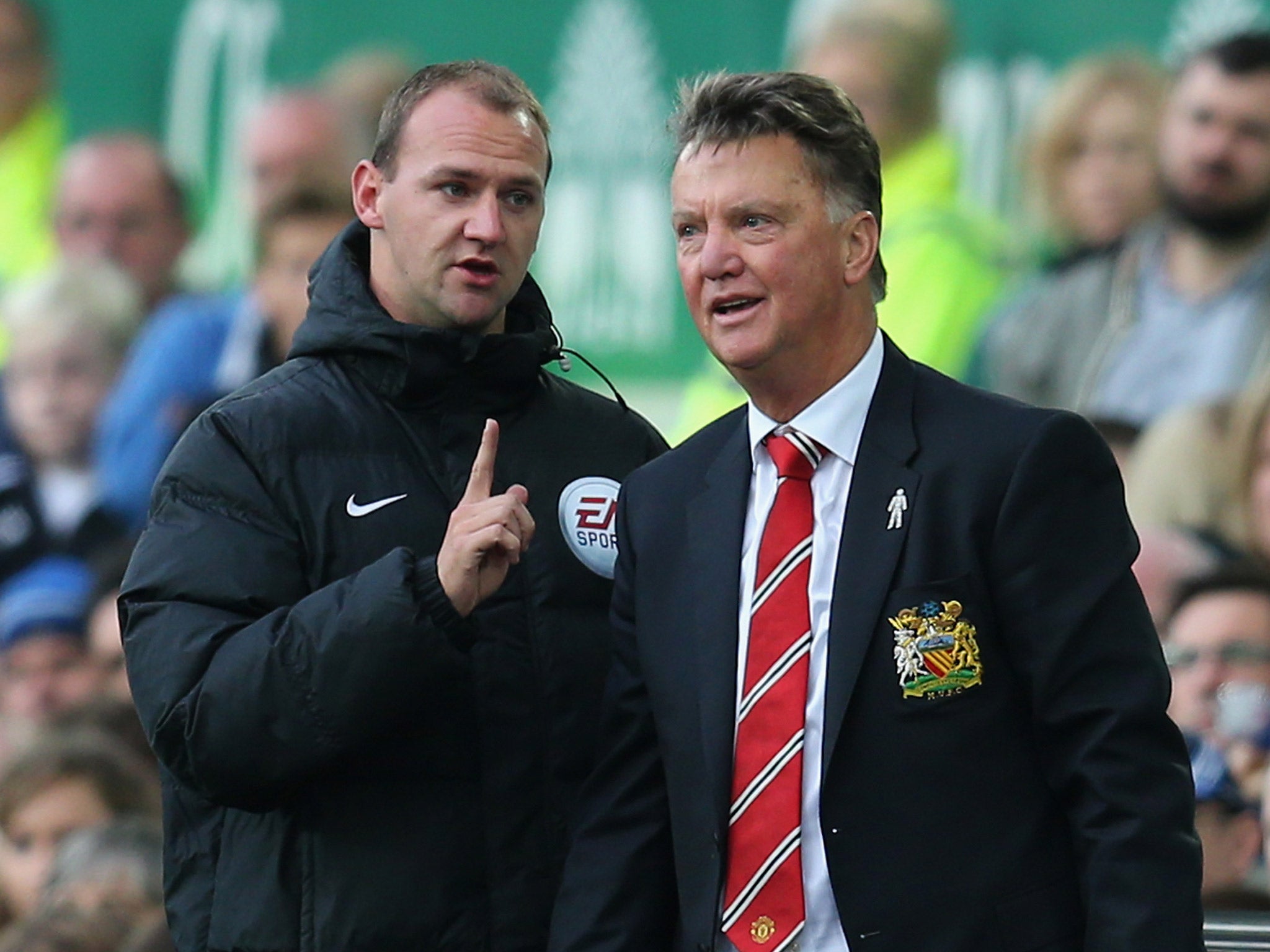 Louis van Gaal speaks with the fourth official during the match against Everton