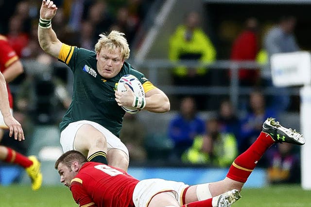 Dan Lydiate, of Wales, tackles South Africa’s Adriaan Strauss