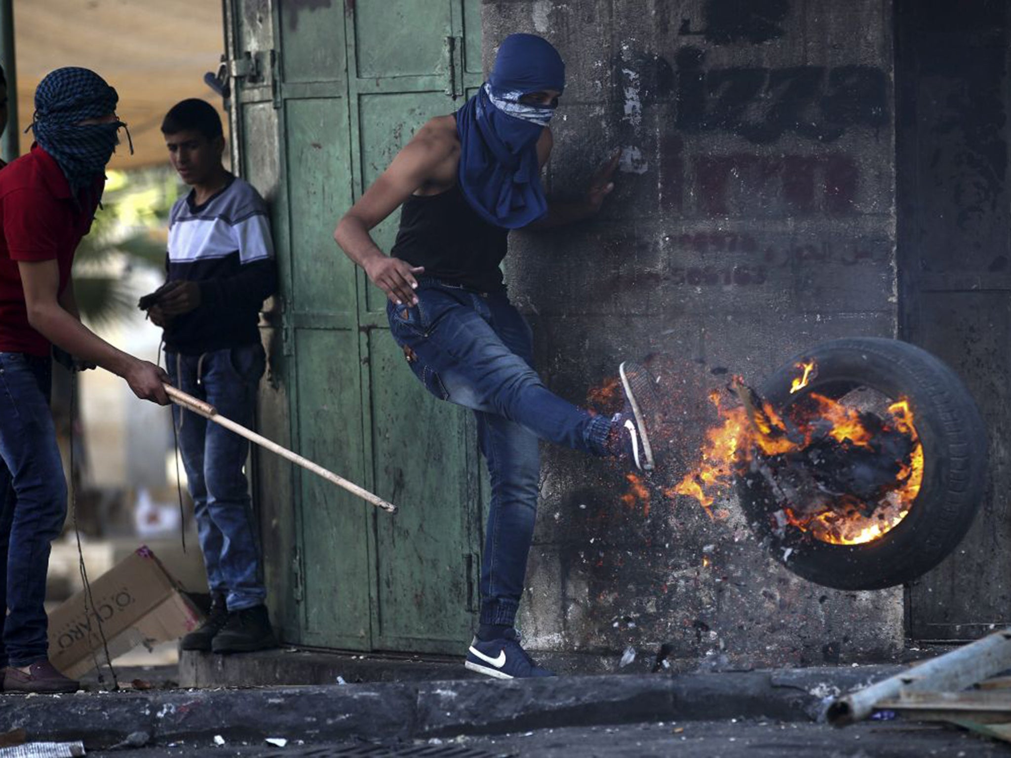 A Palestinian protester clashes with Israeli soldiers in Hebron on Saturday