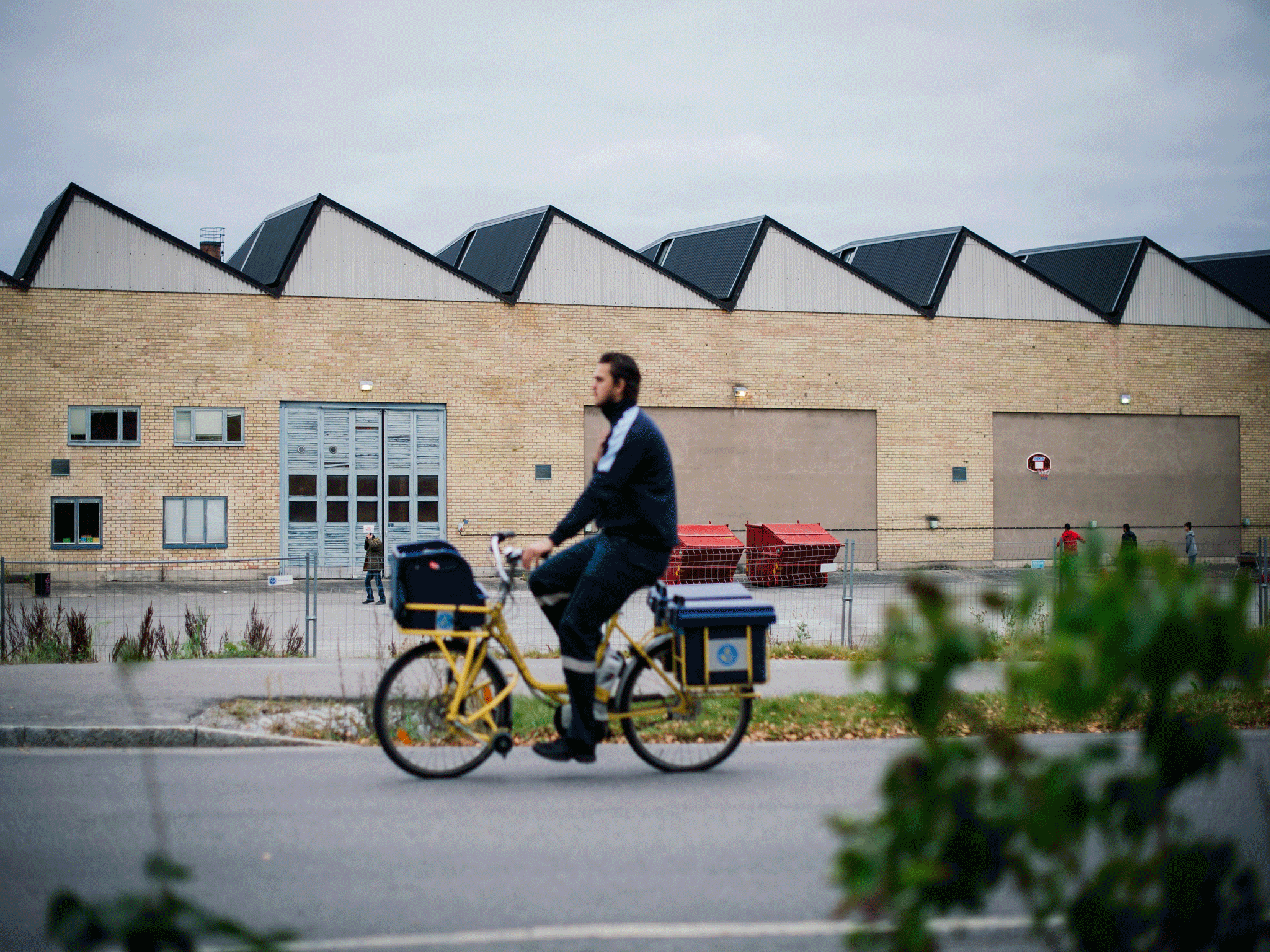A postman cycle past a refugee centre in Sundyberg, north-west of Stockholm. 44% of Swedes think the country should take more families fleeing violence
