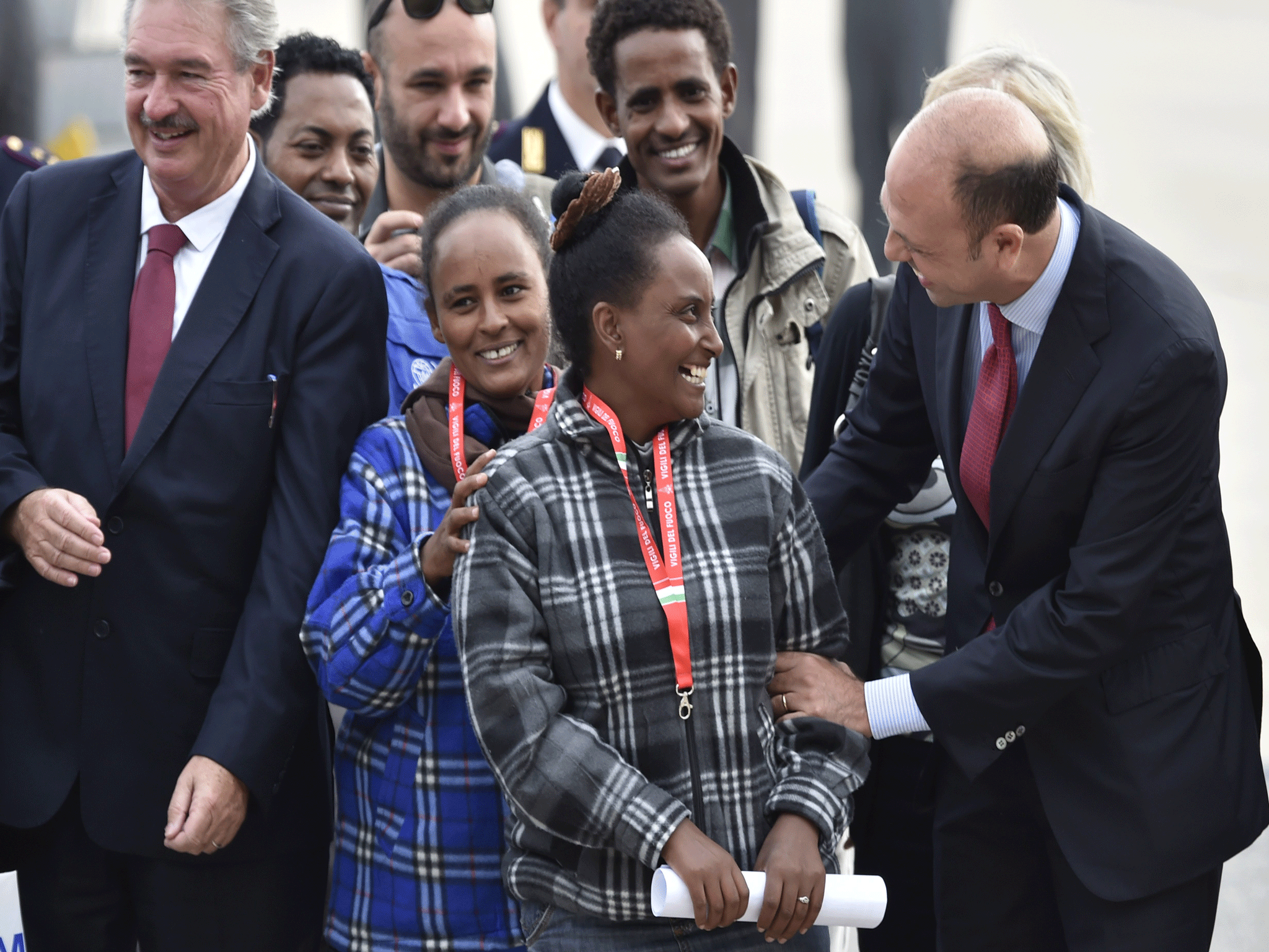 Two European politicians greet Eritrean refugees before they board a flight to Sweden