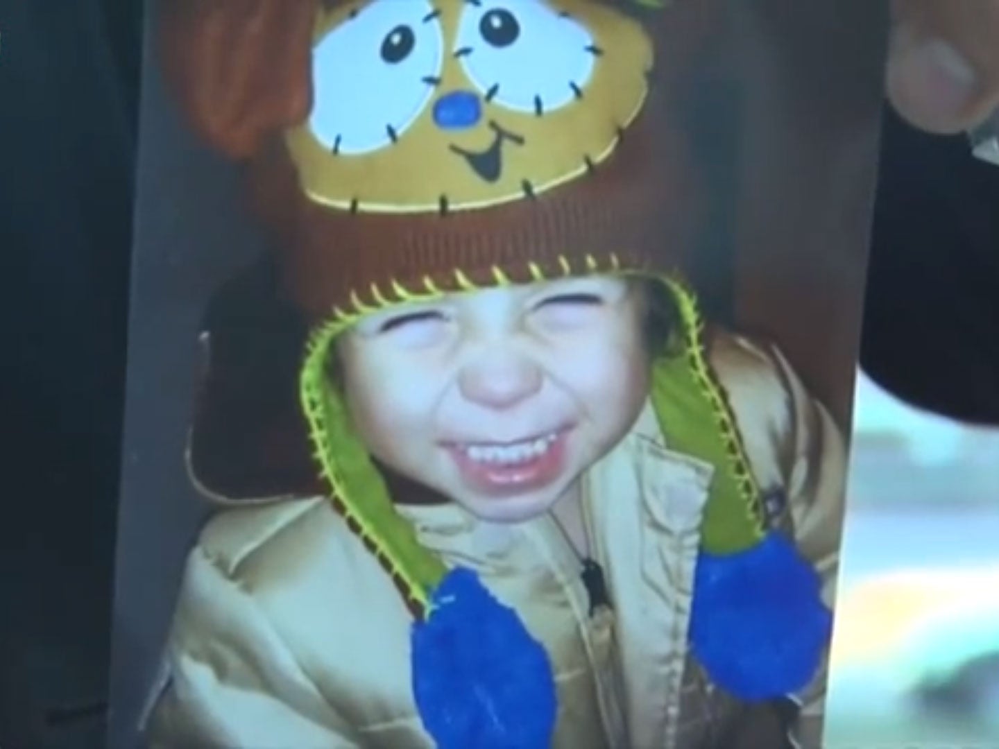 Grandfather Israel LeSalle holds a picture of three-year-old Eian Santiago