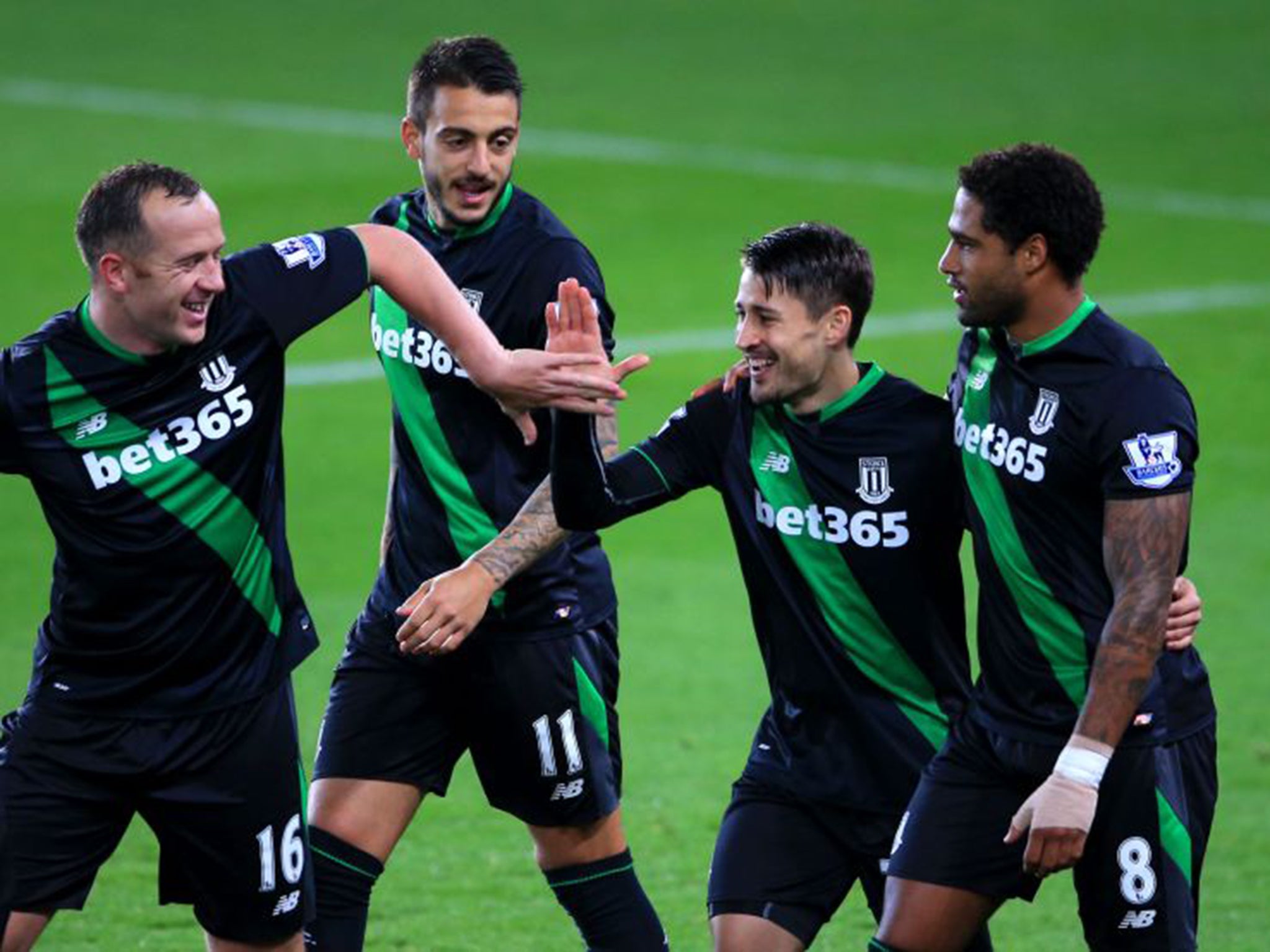 Bojan is mobbed by his Stoke team-mates after his early winner from the penalty spot