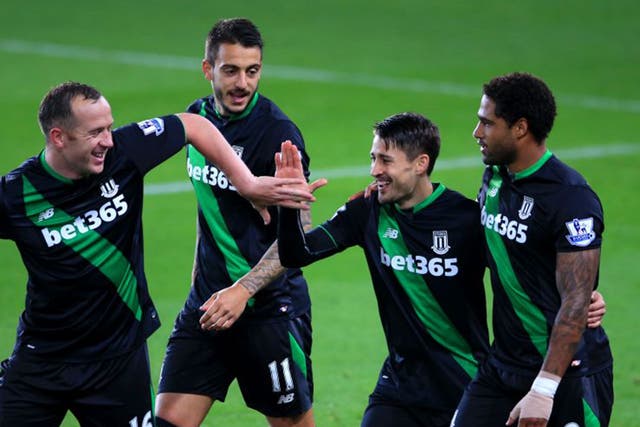 Bojan is mobbed by his Stoke team-mates after his early winner from the penalty spot