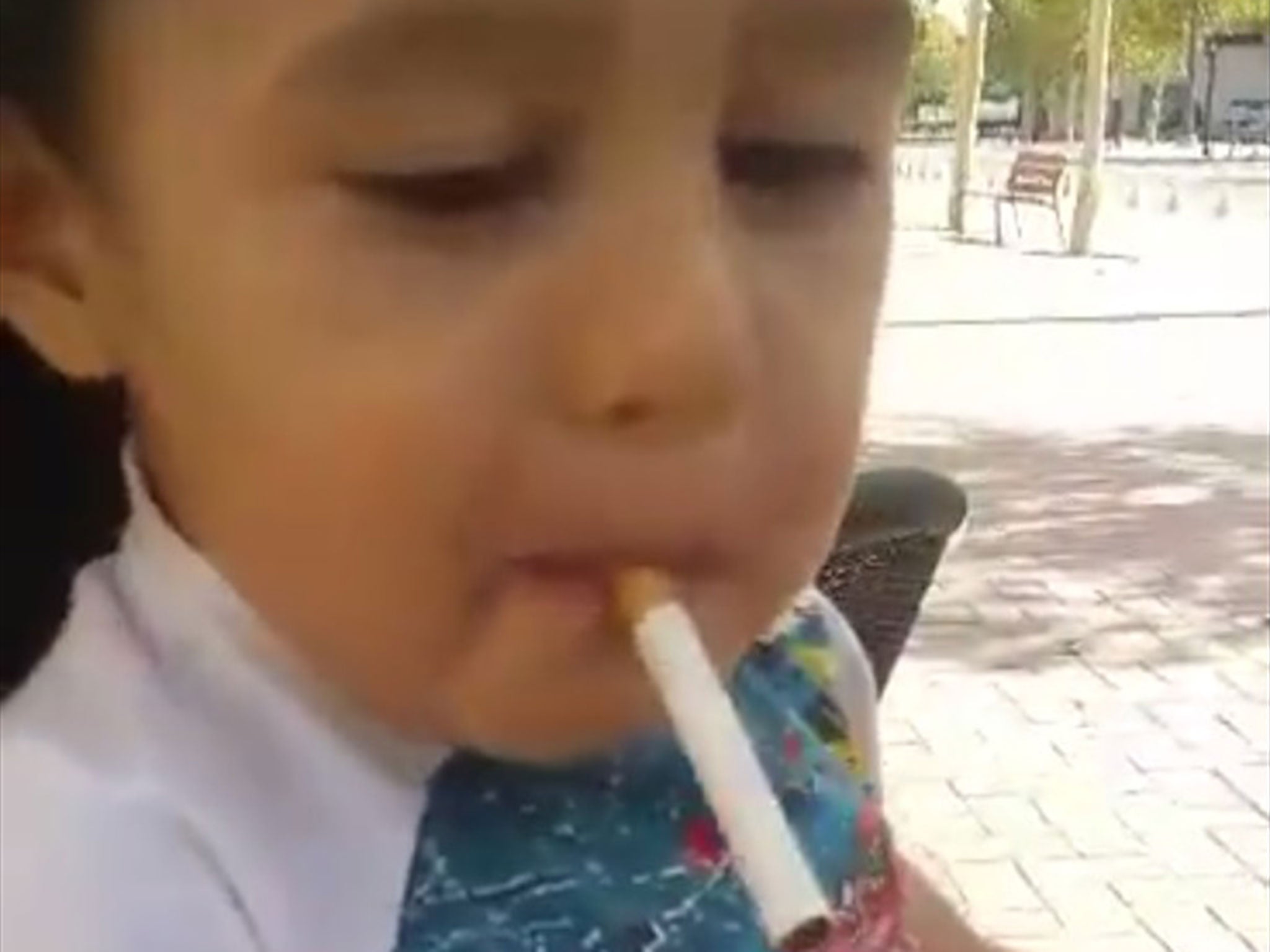 A man lights a cigarette for the little boy